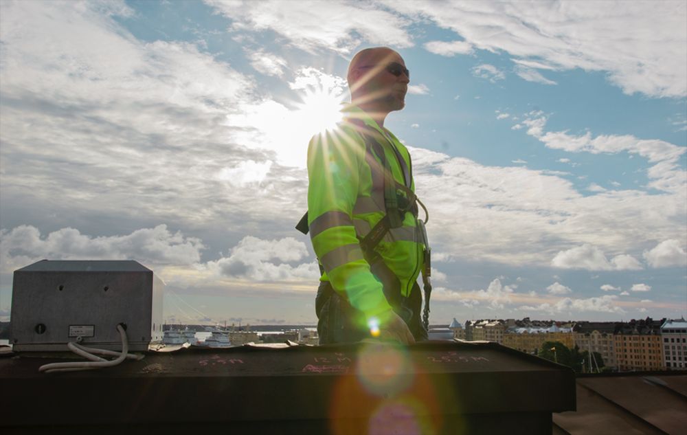 Tuloilma.comin työntekijä kohteen katolla kauniilla puolipilvisellä säällä